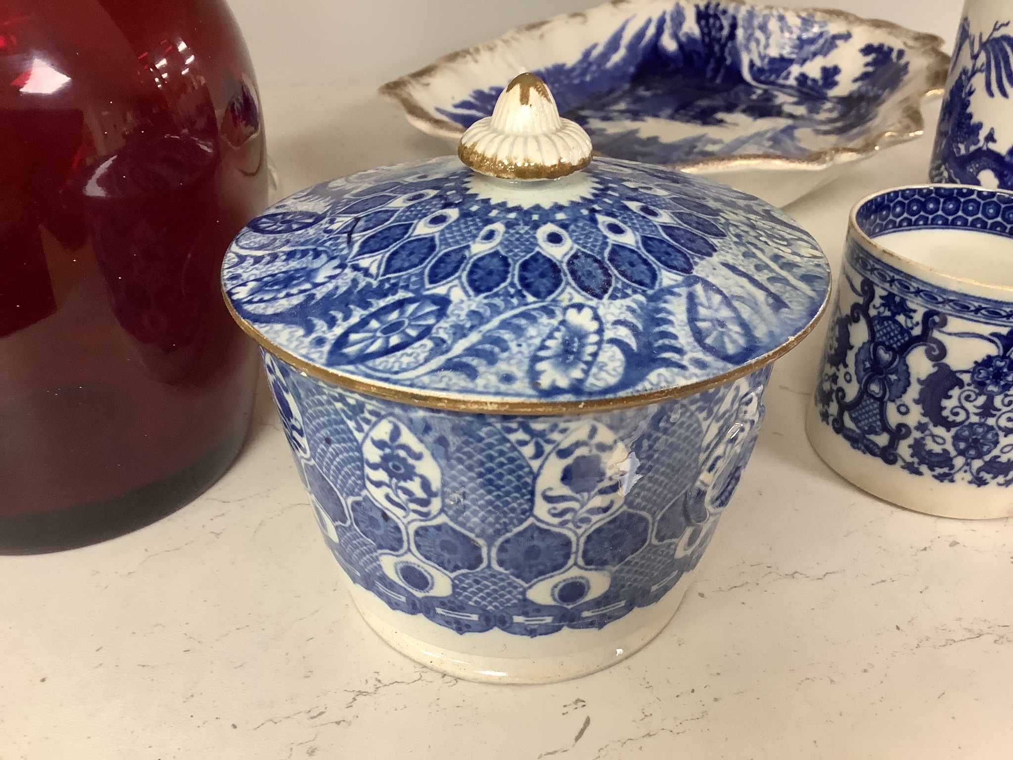 A collection of English blue and white pottery, various dates, comprising a moulded hexagonal teapot and cover, with widow finial, ovoid teapot and cover, lozenge section sugar bowl and cover, with swan finial, circular